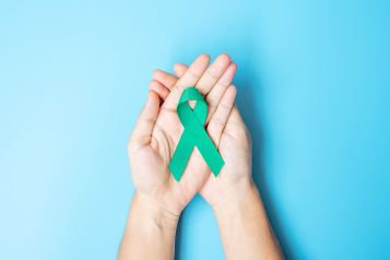 Ovarian Cancer Awareness month ribbon held in a pair of hands
