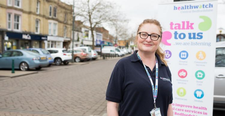 Volunteer standing in front of a pop up banner