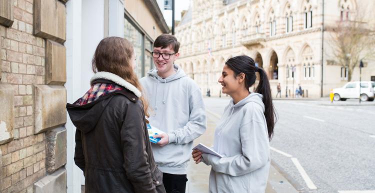 Two teenage Healthwatch volunteers talking to a member of the public about their experience