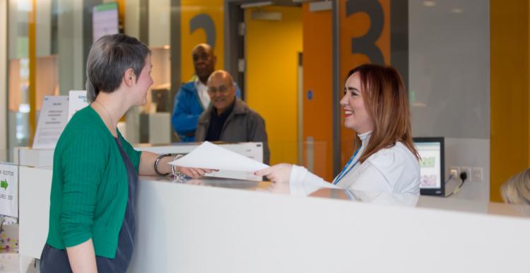 Woman speaking to someone at the hospital reception