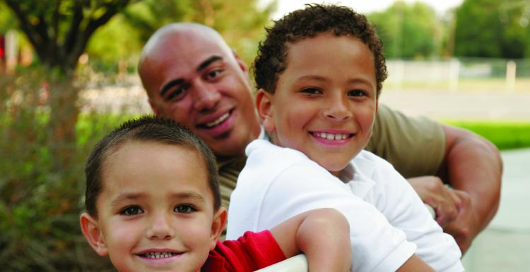 Man smiling with his two young children