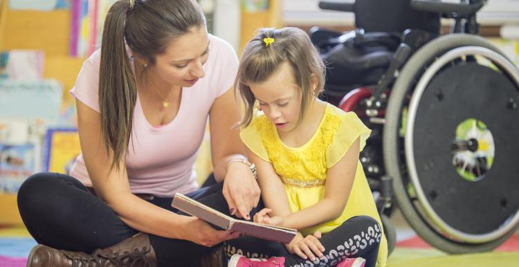 A woman reading a book to a young girl