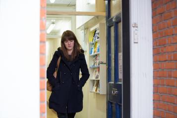 Woman alone walking out of the door looking down